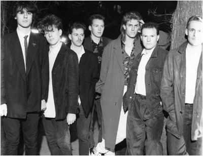 Publicity photo of BASH OUT THE ODD taken outside Birmingham International Airport in March 1990. The line up on this is (left to right) - Mark Brindley, Mark Mortimer, Martin Cooper, Pete Woodward, Stuart Pickett, Bryan Hurdley, Mark Allison.